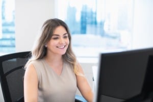 Employee in office on computer communicating with virtual assistant